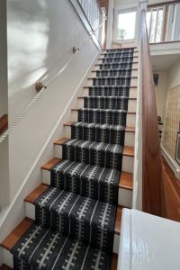 Black and white stair runner from bottom of stairs.